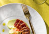 6 of the Freshest Seafood Spots in Pittsburgh An above shot of a seafood dish, served on a white plate with a gold fork on the right side of the meal.