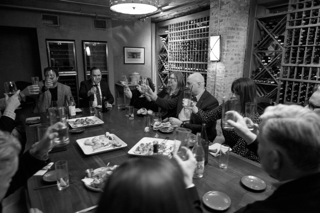 A group of Downtown Pittsburgh owners sit at a dinner table at Vallozzi's.