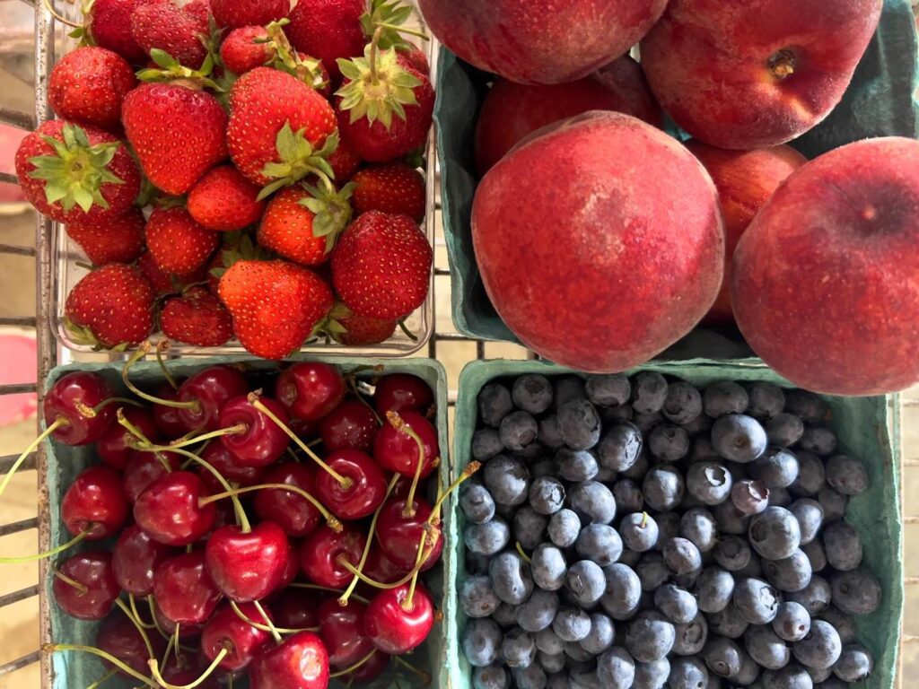 Four Basket with strawberries, apples, cherries, and blueberries inside each.