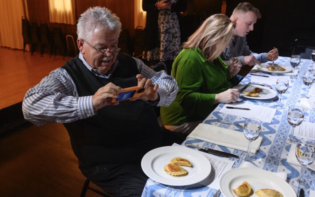 Rick Seback takes a photo of his pierogi plate at a tasting party.