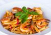 Monterey Bay Fish Grotto Serves Up Specialty Cocktails and Fresh Seafood to Match A white dish with pasta and shrimp with a red sauce garnished with green basil