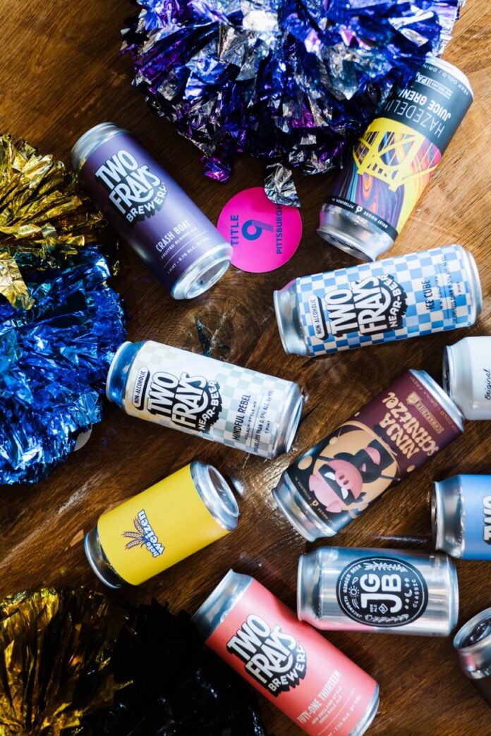 Various cans of craft beer sit amongst pompoms at a Pittsburgh sports bar.