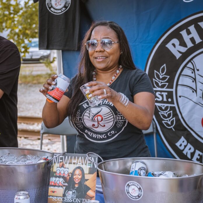 A woman pours a beer into a clear cup at Barrel and Flow Fest.