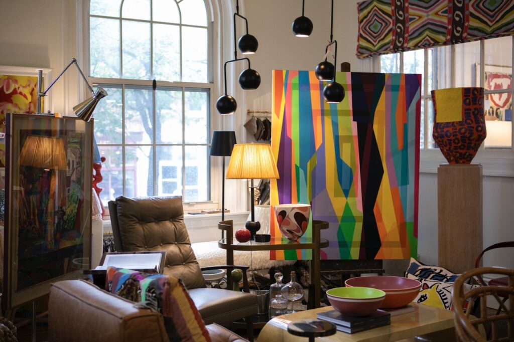 Shoppe B space with paintings, mood lighting, chairs, and other decor.