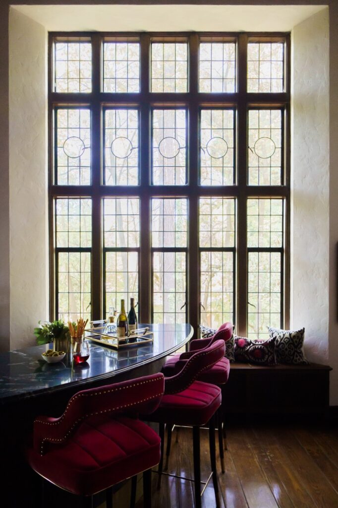 A large rectangular window with a table and chairs in front of it.
