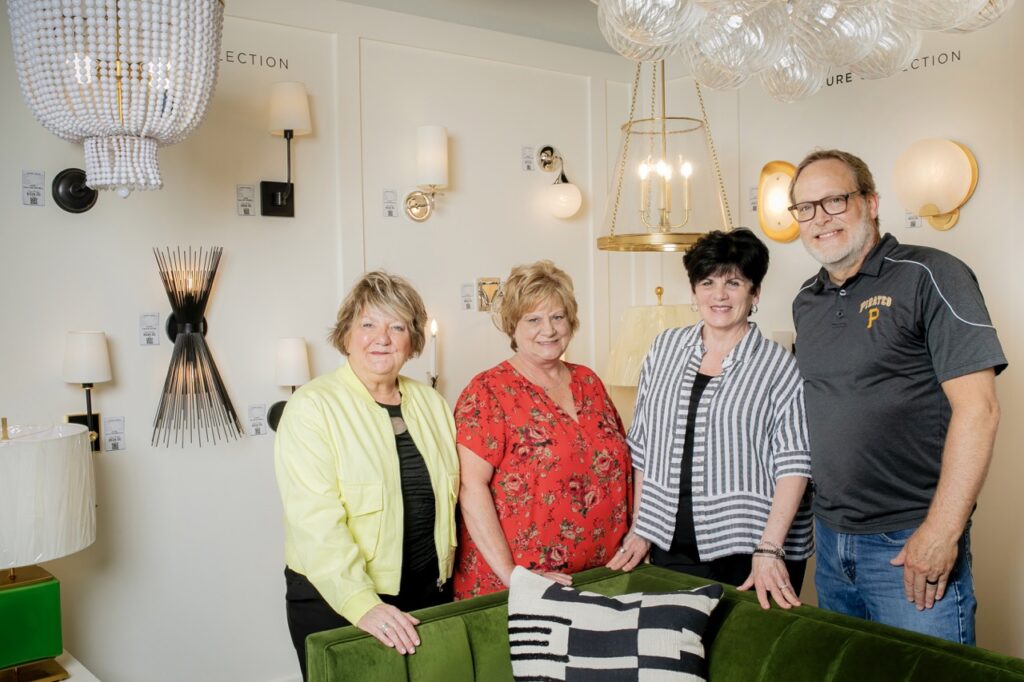 Three women and a man stand under the lighting displays at Cardello.