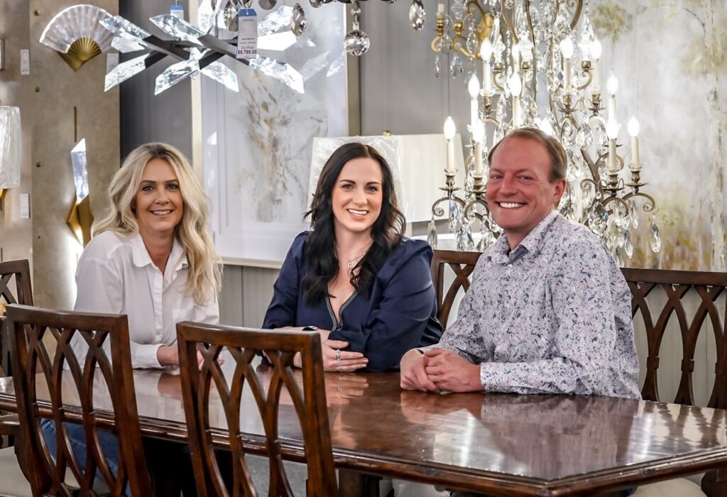 Two women and a man sit at a dining table.