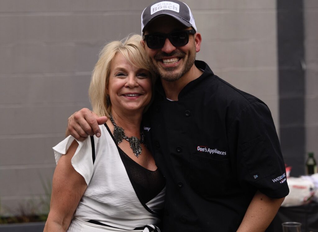 A man from Don's appliances and a woman in white stand together at Table magazine's design industry event.