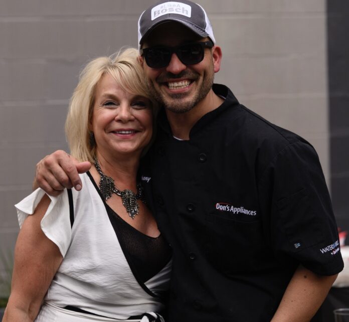 A man from Don's appliances and a woman in white stand together at Table magazine's design industry event.