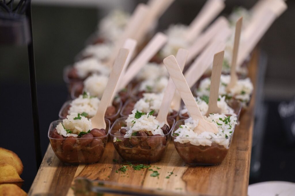 Beans and rice in small servings with a wooden fork.
