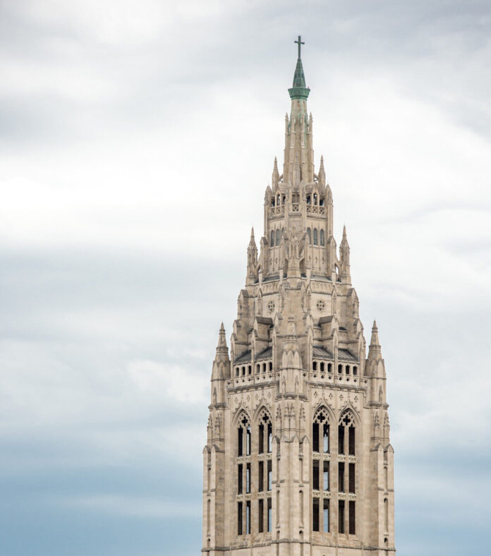 The outside of East Liberty Presbyterian Church in Pittsburgh stretching into a blue and cloud sky.