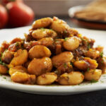 On a white plate sits a mound of GIANT BEANS WITH HONEY AND DILL.