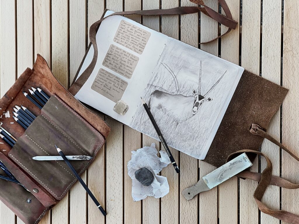 Various journals and pens lay on a table.
