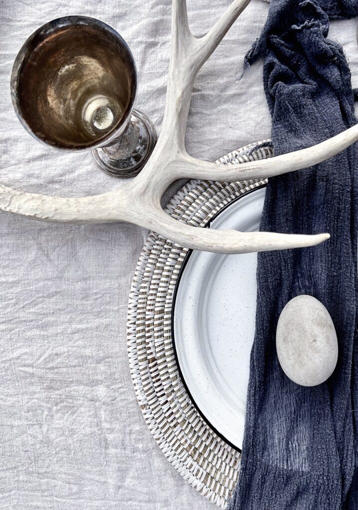 A antler sits across a glamping plate setting.