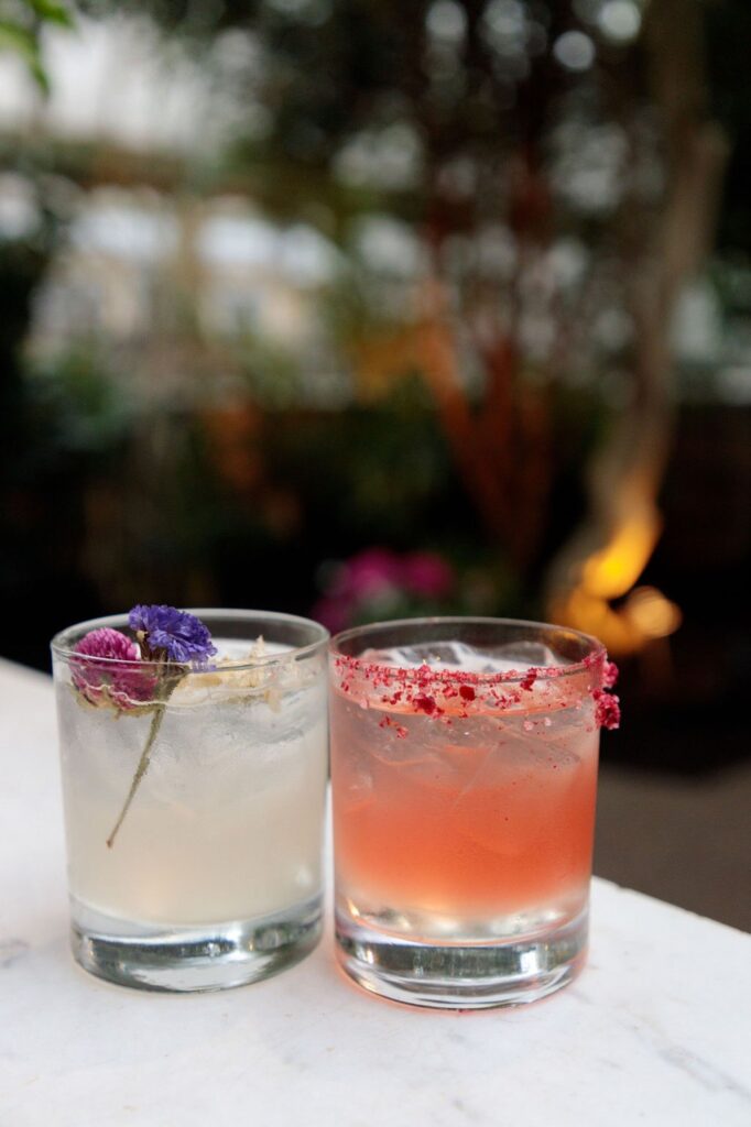 Two floral cocktails sit on a white table.