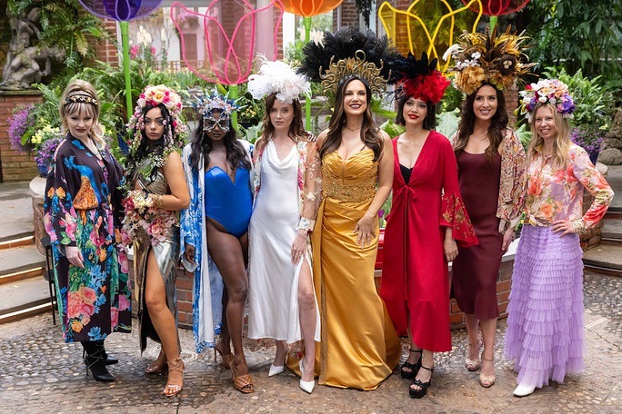 A group of women in various bright colored dresses.