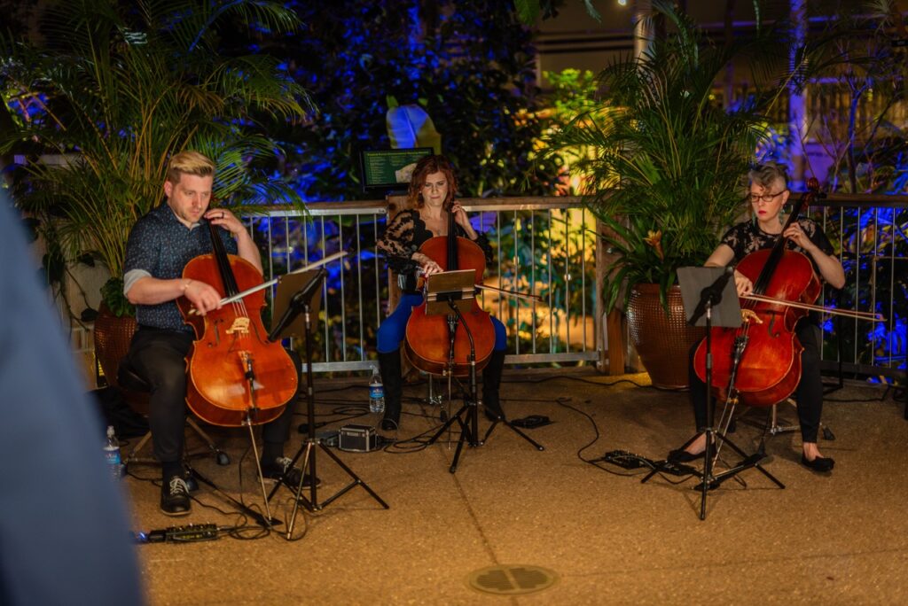 A string trio plays on a balcony.