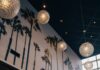 East Liberty Restaurant Palm Palm is Your Ticket to Paradise in Pittsburgh A wall of palm tree art with glowing orb lights hanging from the ceiling of the Palm Palm dining room.