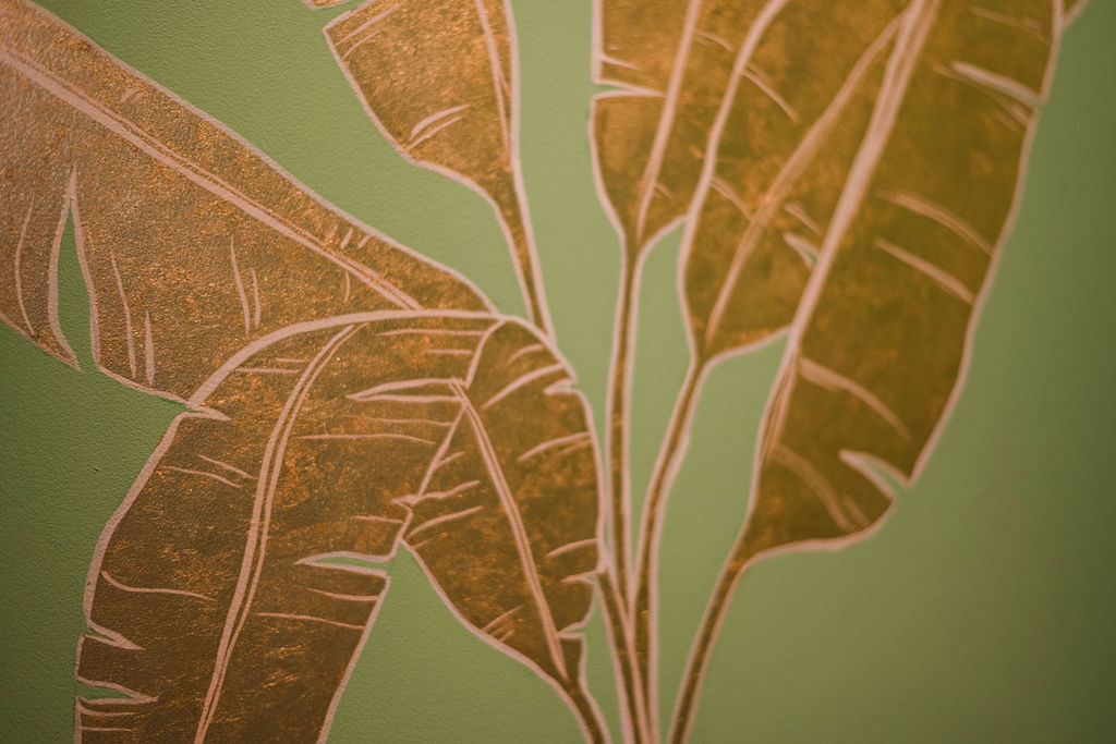 Gold palm leaves painted on the wall of Palm Palm by Daniel Bland.