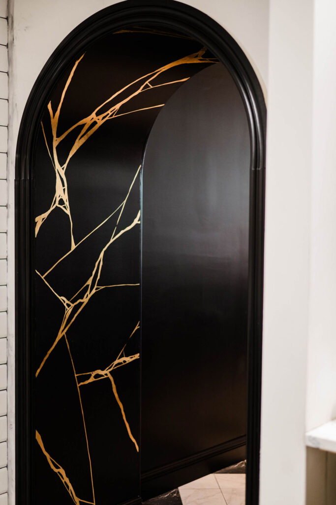 The black kitchen archway at Palm Palm painted with gold embellishments by Daniel Bland.