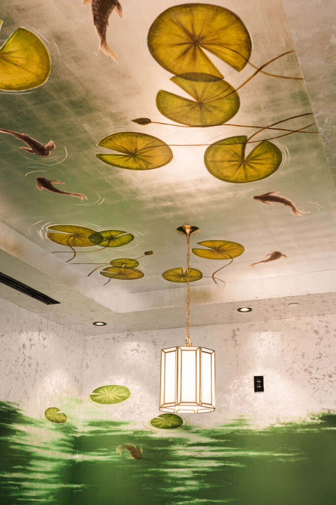 A ceiling mural featuring lily pads and koi fish.
