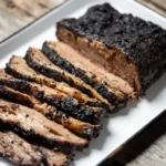 On wooden surface sits a very tender looking brisket from Spork Pit.