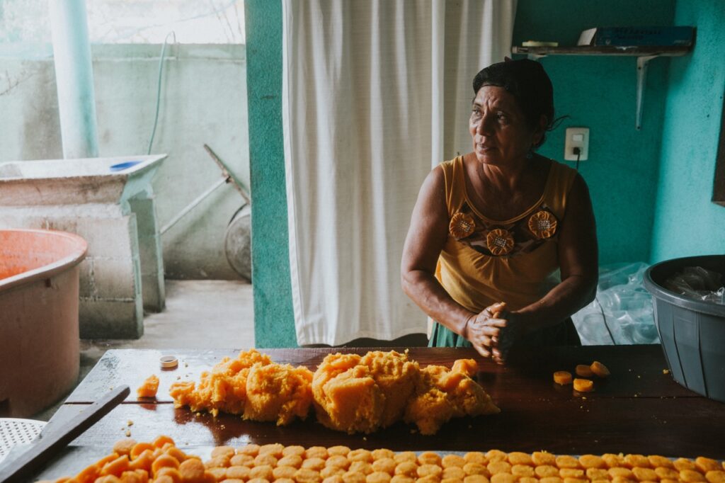 A woman mashes up fruit with her hands.
