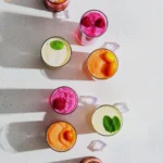 An aerial view of eight brightly colored frozen cocktails