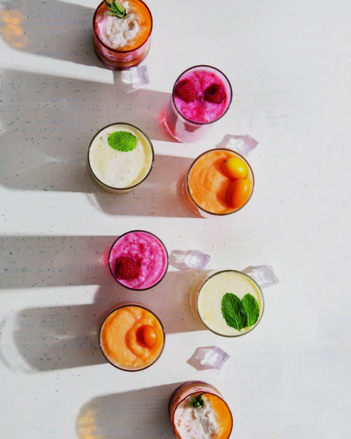 An aerial view of eight brightly colored frozen cocktails