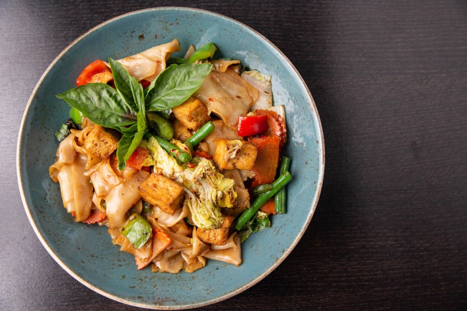 A plate of Thai food from Senyai on a black background.