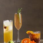 An enticing display of a trio of fall cocktails. Each cocktail is expertly garnished and presented in elegant glassware.