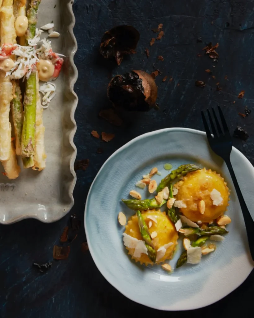 An above shot of Asparagus ravioli on a small white plate.