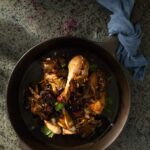 An above shot of a brown ceramic bowl filled with Chicken Marsala.