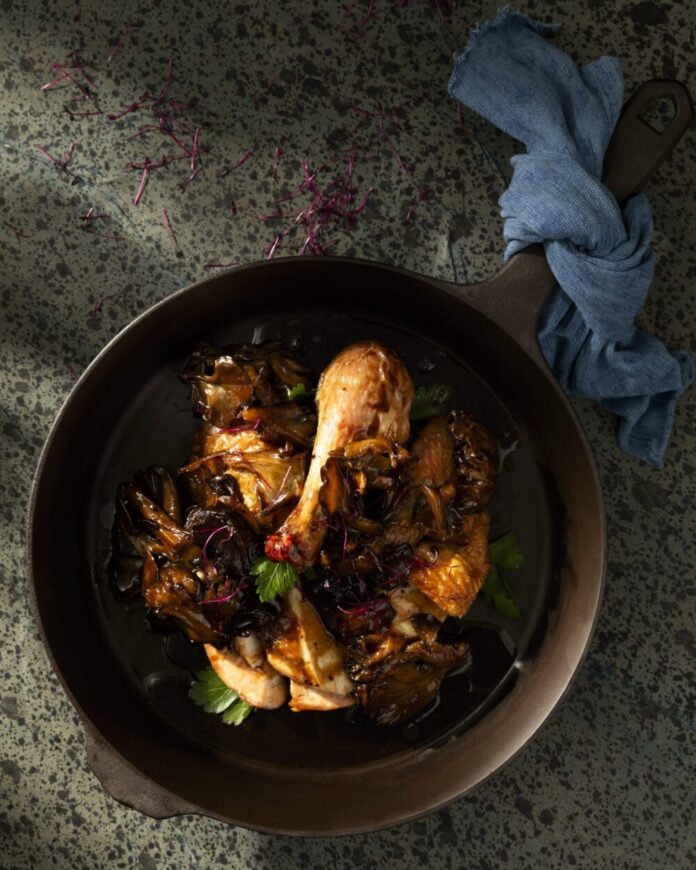An above shot of a brown ceramic bowl filled with Chicken Marsala.