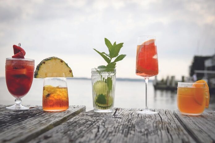 A dock of various fruit cocktails with extravagant garnishes.