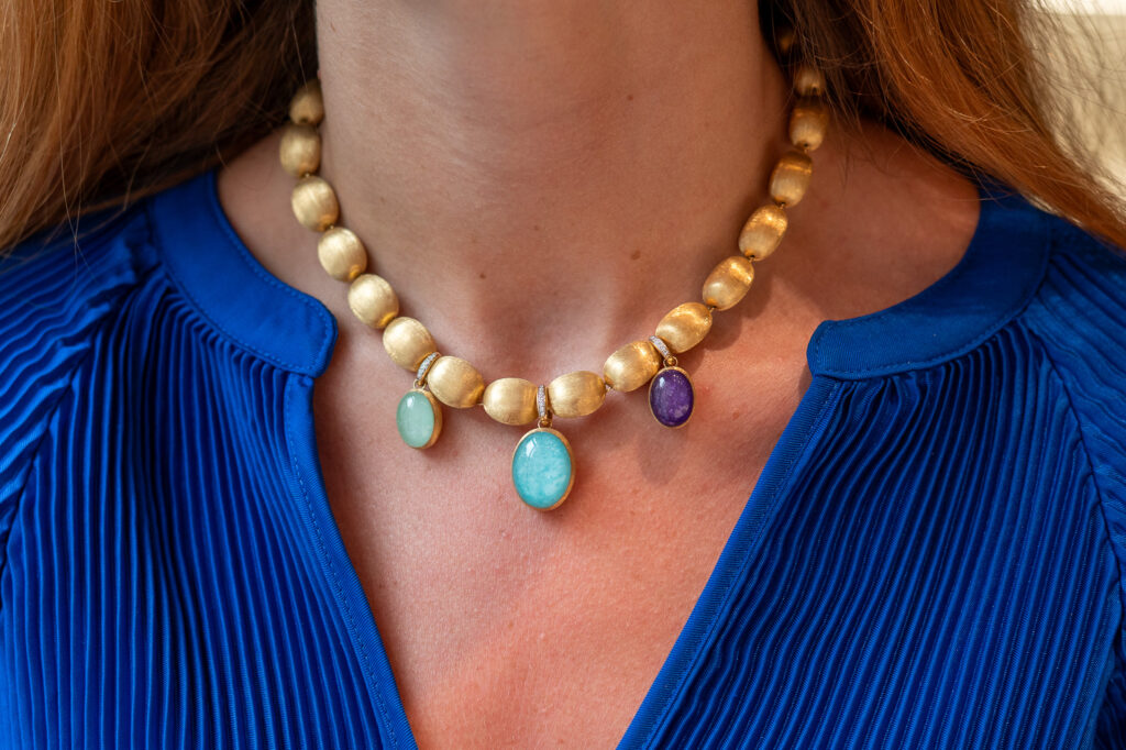 An 18K yellow gold Muse necklace by Nanis is finished with 18K yellow gold gemstone and diamond charms.