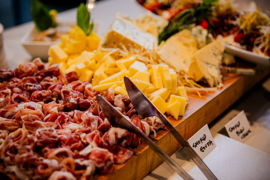 A cutting board full of meats and cheese.