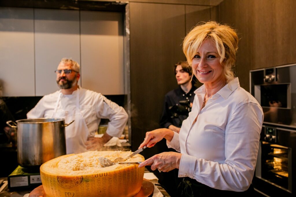 A woman prepares pasta in a cheese wheel.