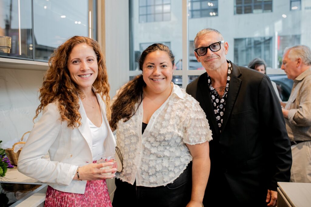 A group of people smile together in white and black.