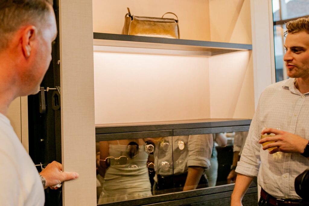 Two men look at a shelf of watches.
