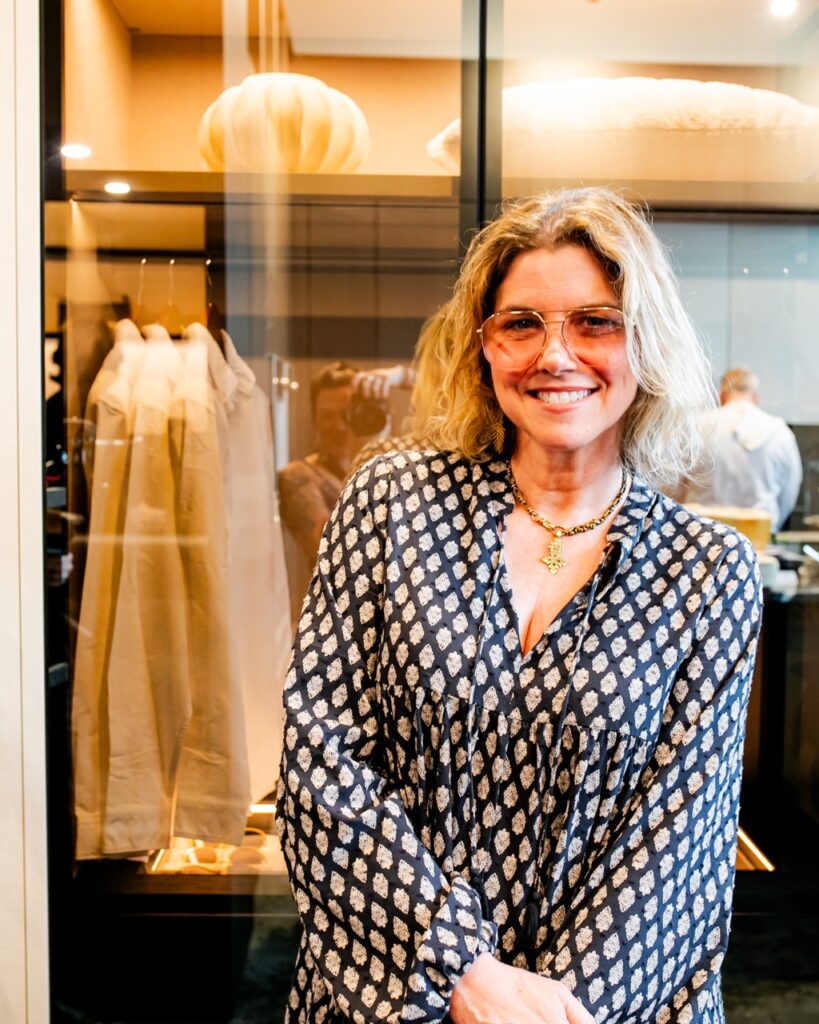A woman in a black and white dress wears sunglasses.