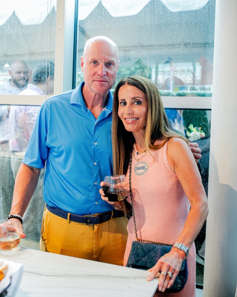 A man and woman stand together behind a marble countertop.