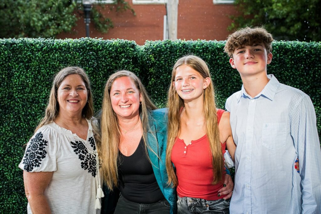 Two women stand with a young girl and boy.