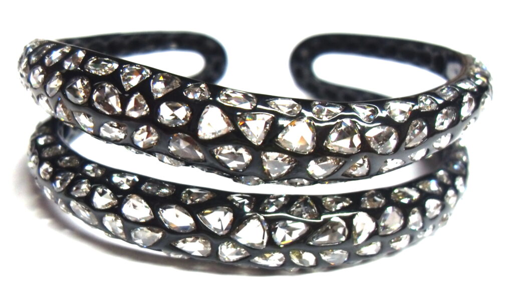 Etho Maria plays with dark and light in this 18K gold cuff bracelet coated in black rhodium. Nearly 12 carats of white, rose-cut diamonds gleam beautifully out of this luxurious darkness.