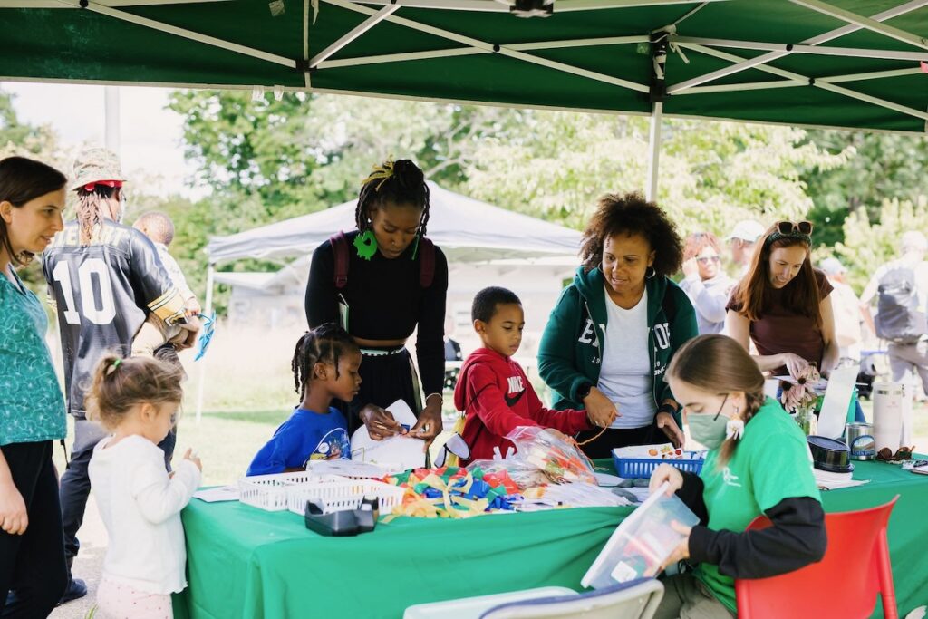 A group of families gather around a craft table at Pittsburgh's Freedom Harvest Celebration.