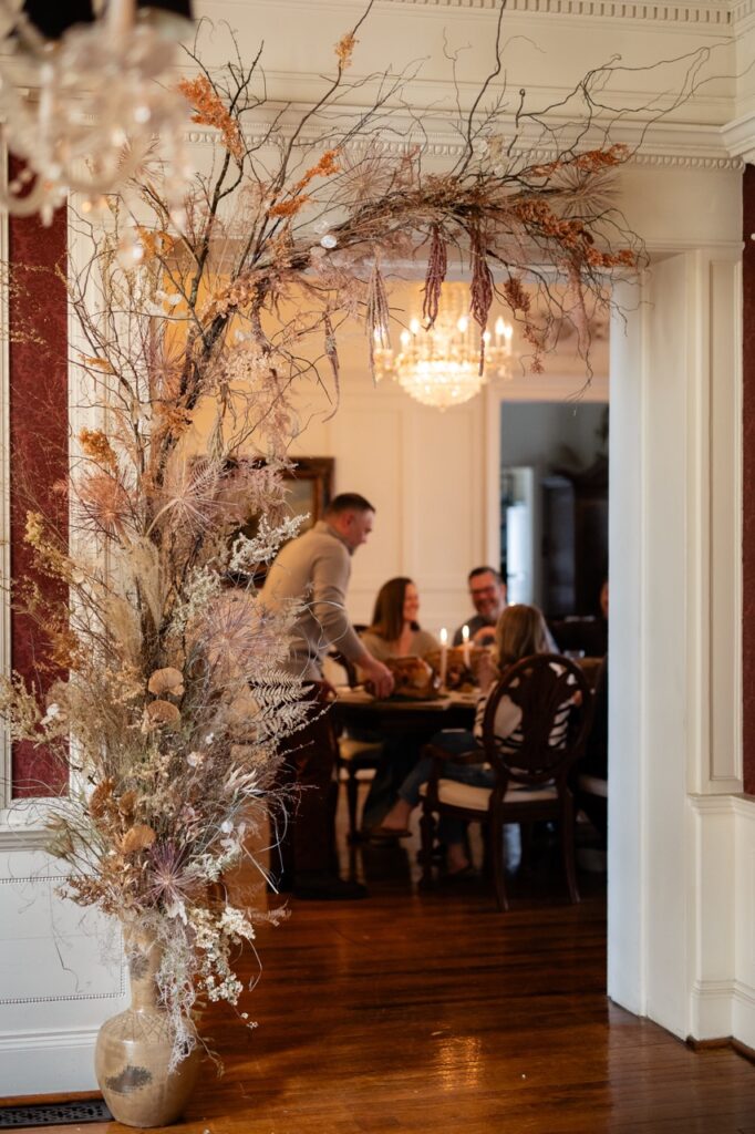 Through a doorway, people sit at a dining table.