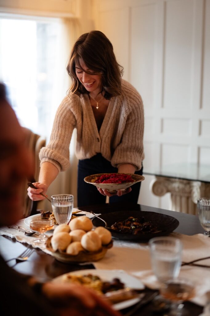 A woman scoops food onto her plate.
