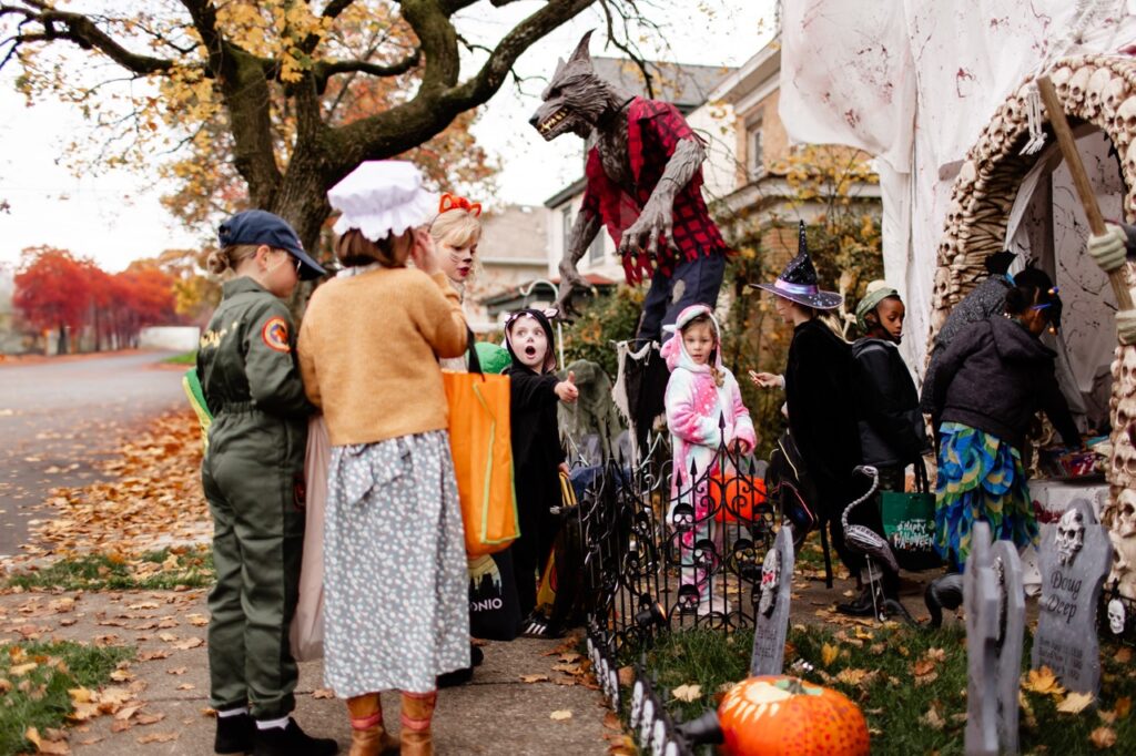 A group of kids walk past a Halloween decorated house.