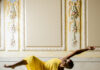 Choreographer Jasmine Hearn Uses Their Body as an Artistic Tool A woman dances in a yellow dress with her arms and legs outstretched.