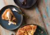The Best Martha Stewart-Inspired Recipes to Fill Your Dining Table On a dark plate sits an Apple Crostada inspired by Martha Stewart which is made with a cheddar cheese crust. One slice has been cut out and sits on another plate with a scoop of ice cream on top.